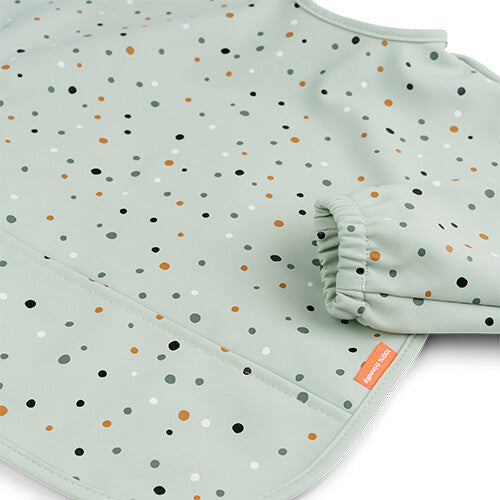 Detail van de groene mouwslab met stippenpatroon en elastische mouwboord.