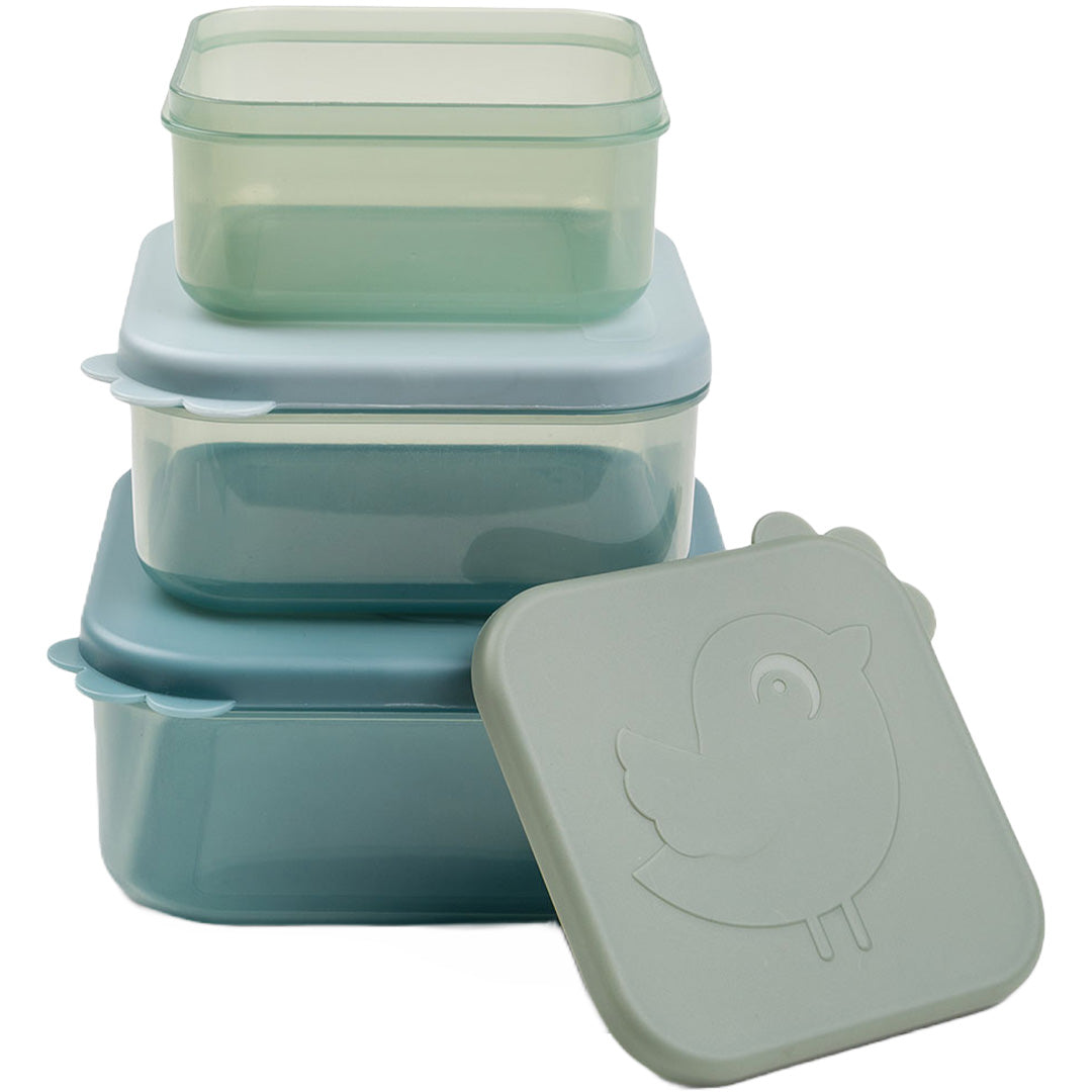Een set van drie done by deer vierkante, stapelbare snackdoosjes met doorzichtige bakjes en blauwgroene deksels, waarvan één met een vogelpatroon.