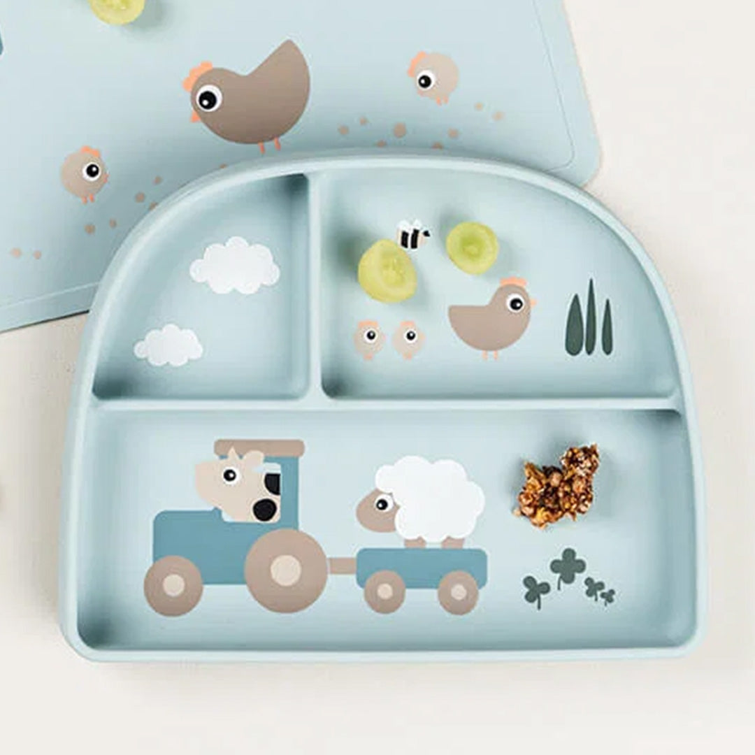 Done by deer siliconen babybord met drie vakjes en Tiny Farm decoratie, deels gevuld met druiven en granola.