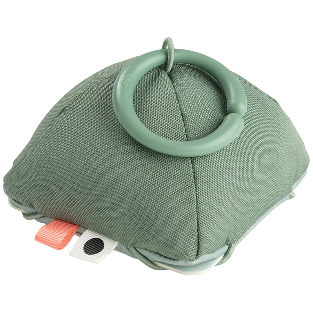 Een groen, zacht done by deer babyspeeltje in de vorm van een kussen met een ring eraan.