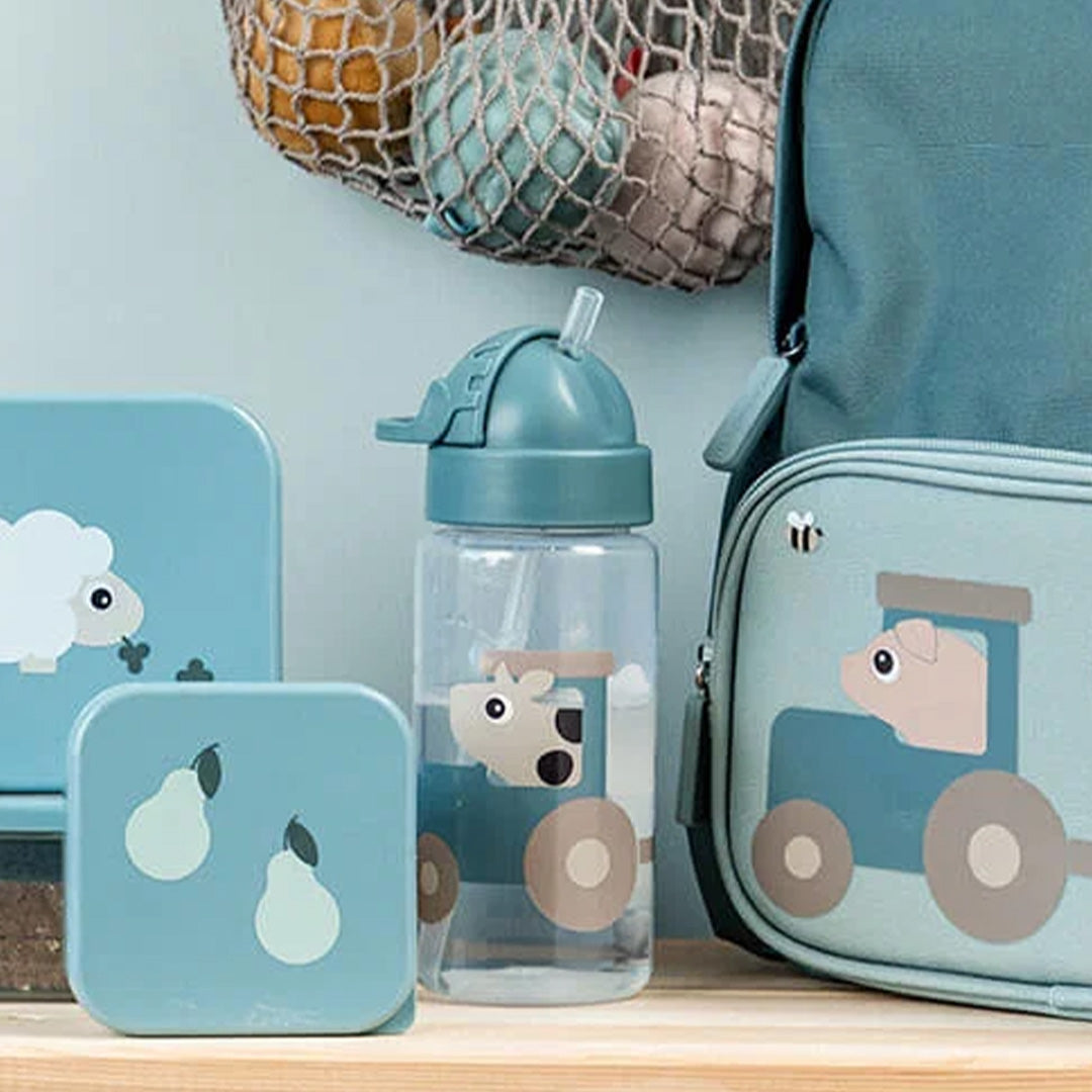 Done by Deer drinkfles met rietje met boerderijdier, staand tussen een bijpassende lunchbox en rugzak.