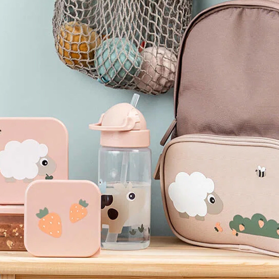Done by Deer drinkfles met rietje met Tiny Farm thema staat naast bijpassende lunchboxen en een rugzak.