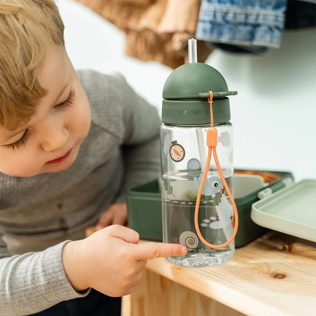 Een kind wijst naar de slak op de Done by Deer drinkfles met rietje Tiny Trails.