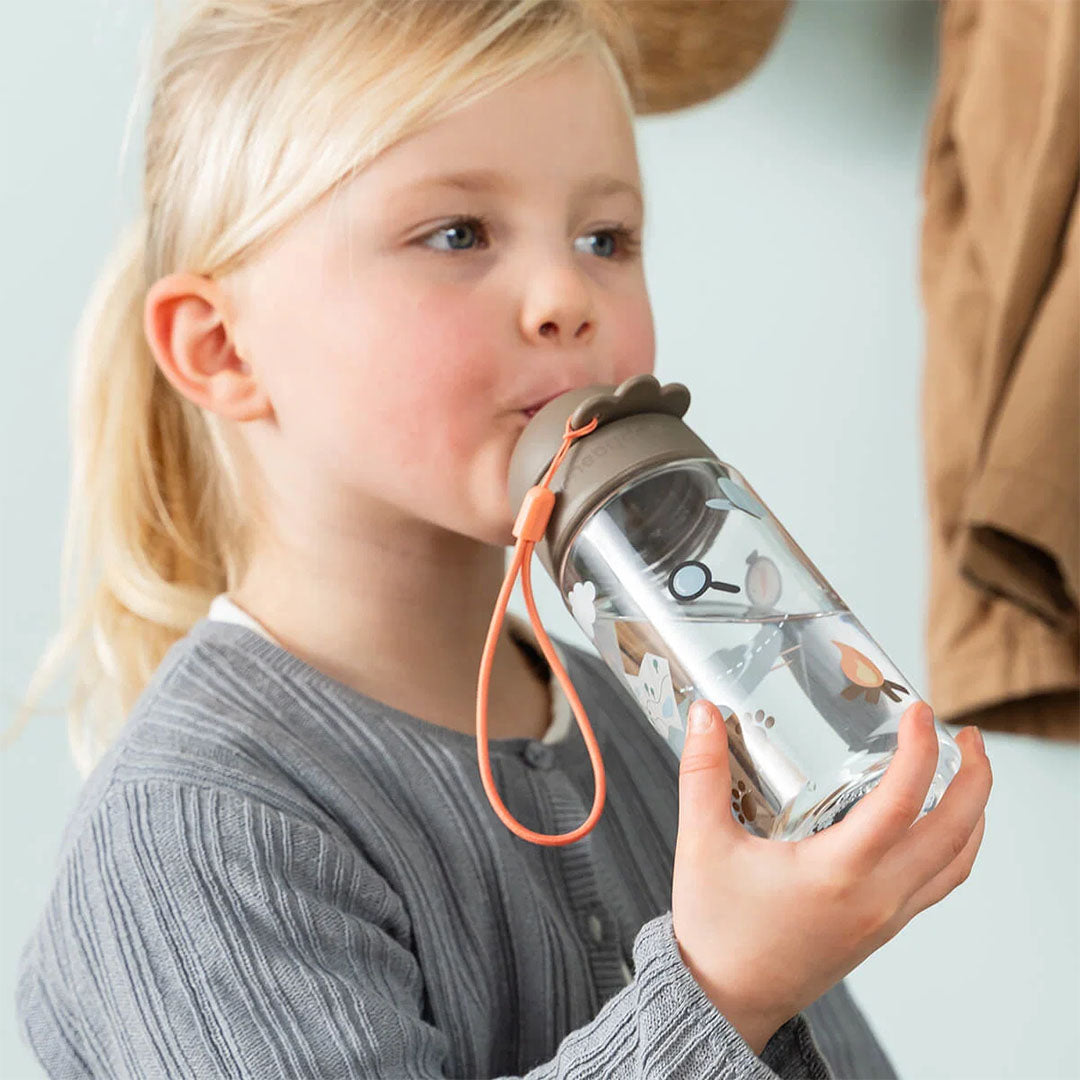 Meisje drinkt uit een done by deer drinkfles met rietje met Tiny Trails dierenpatroon.