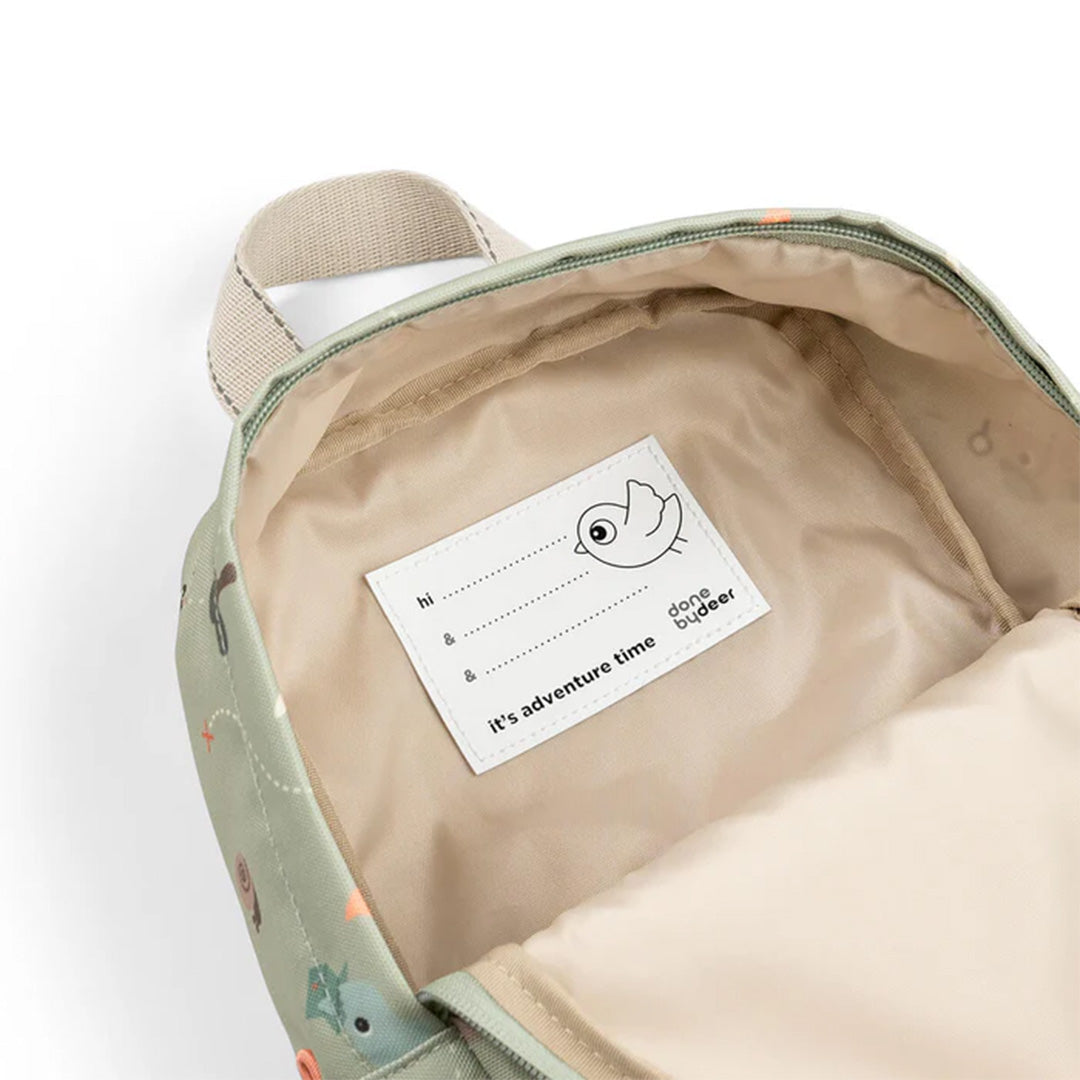 Binnenkant van de open peuterrugzak met beige voering en een naamlabel.