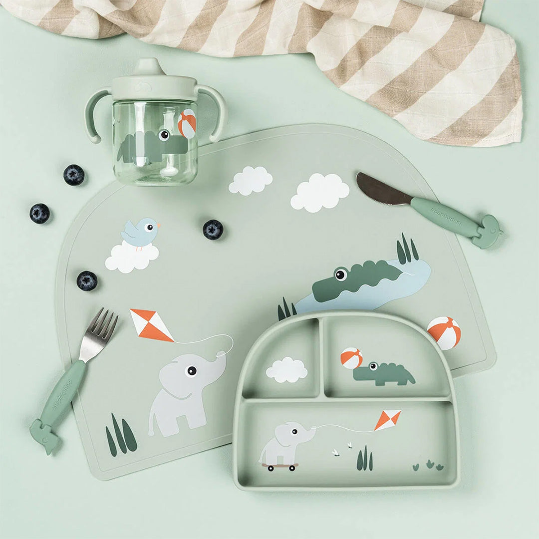 done by deer placemat, bord, beker en bestek met dieren thema, samen op een lichtgroene ondergrond.