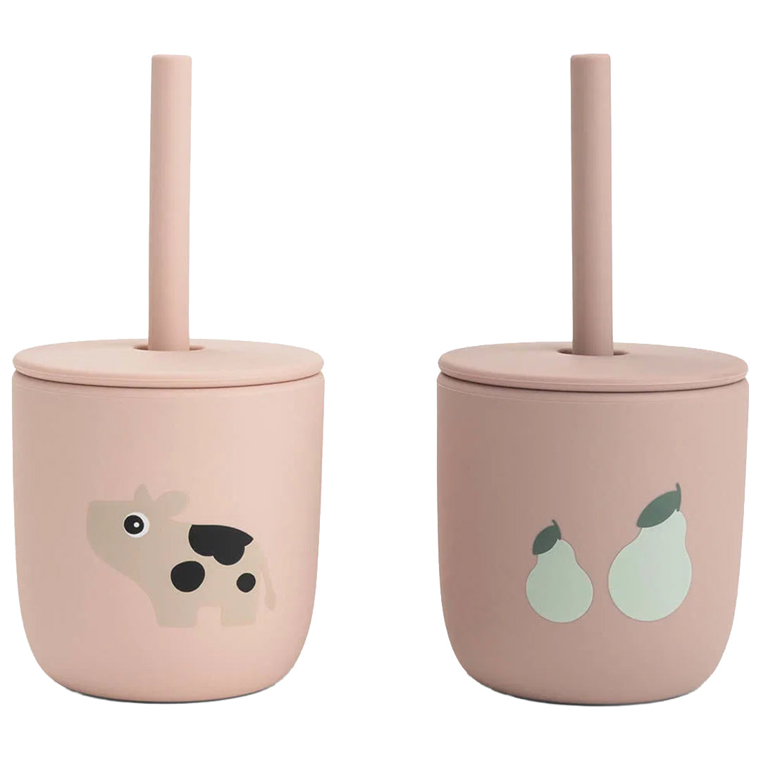 Twee roze done by deer kinderbekers met rietje, één met een koeienpatroon en één met een perenpatroon.