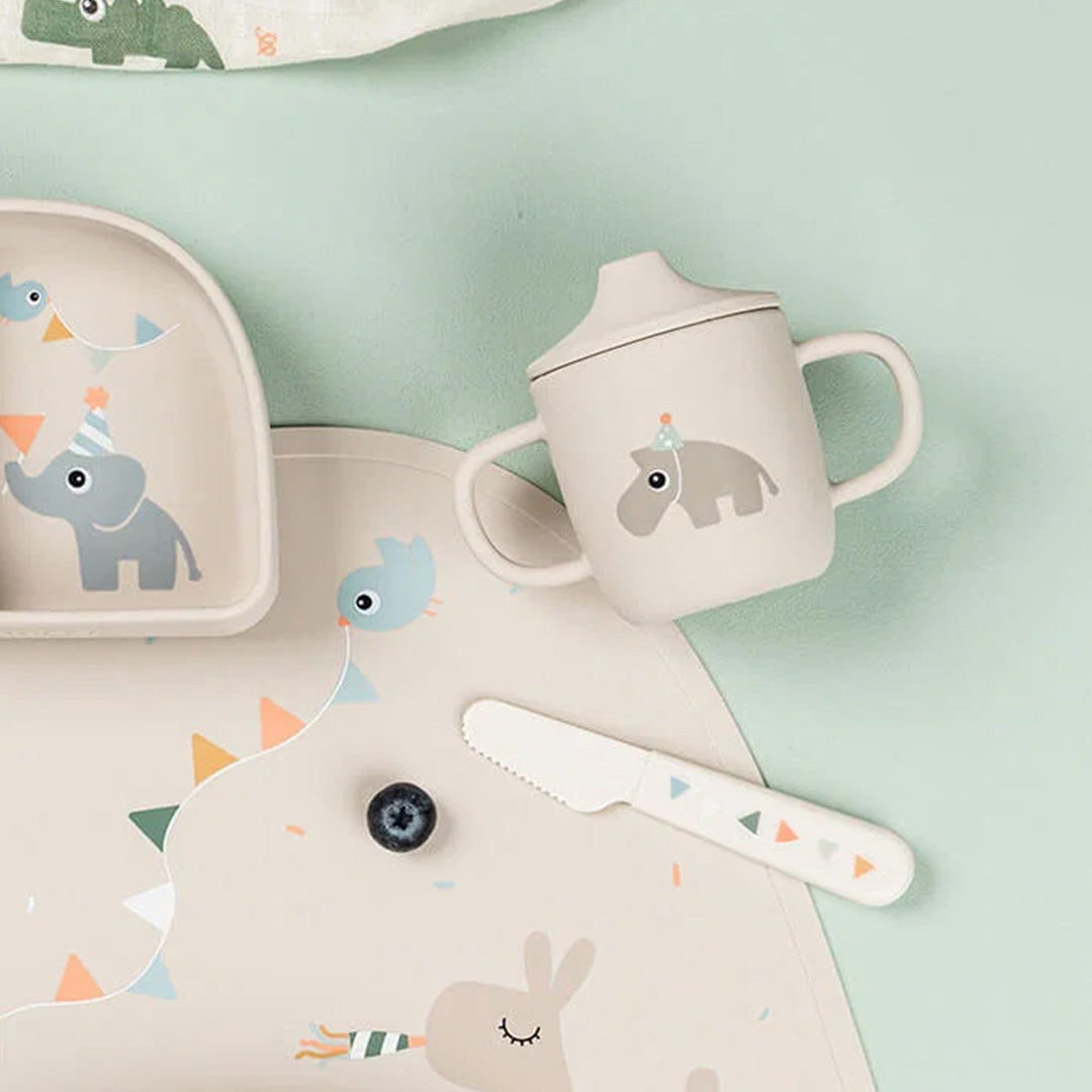 De done by deer siliconen tuitbeker met hippo-opdruk staat tussen bijpassende babyvoedingsartikelen.