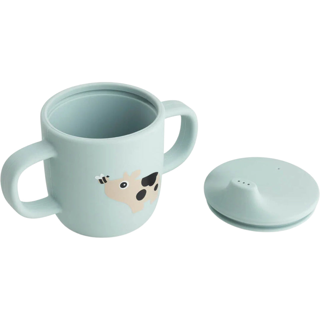 Done by deer siliconen babytuitbeker met koe-illustratie, met de deksel ernaast.