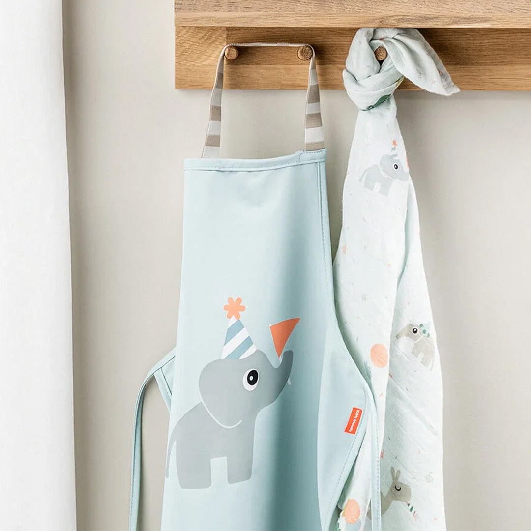 Done by Deer kinderschort met olifant en een bijpassende doek hangend aan een houten rek.