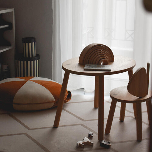 eeveve foam speelmat met beige geometrisch patroon op de vloer met een houten kindertafel en stoel.