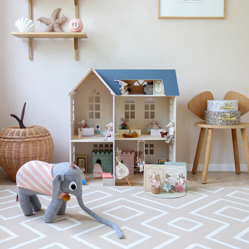 Een speelhoek met een poppenhuis en speelgoed op de eeveve foam speelmat met beige en wit geometrisch patroon.