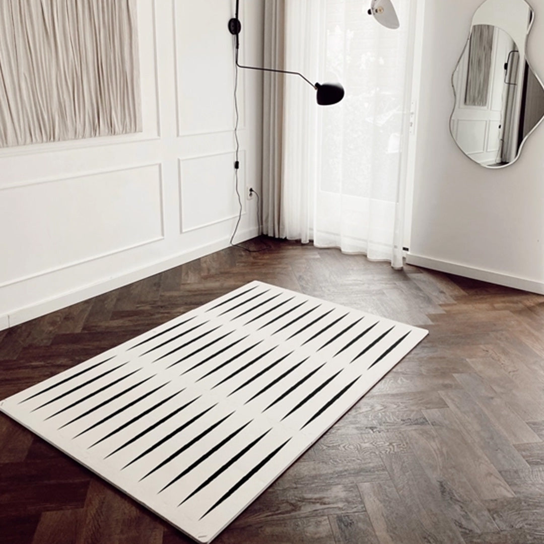 De eeveve foam speelmat met ecru en zwart geometrisch patroon ligt als een vloerkleed in een moderne woonkamer.