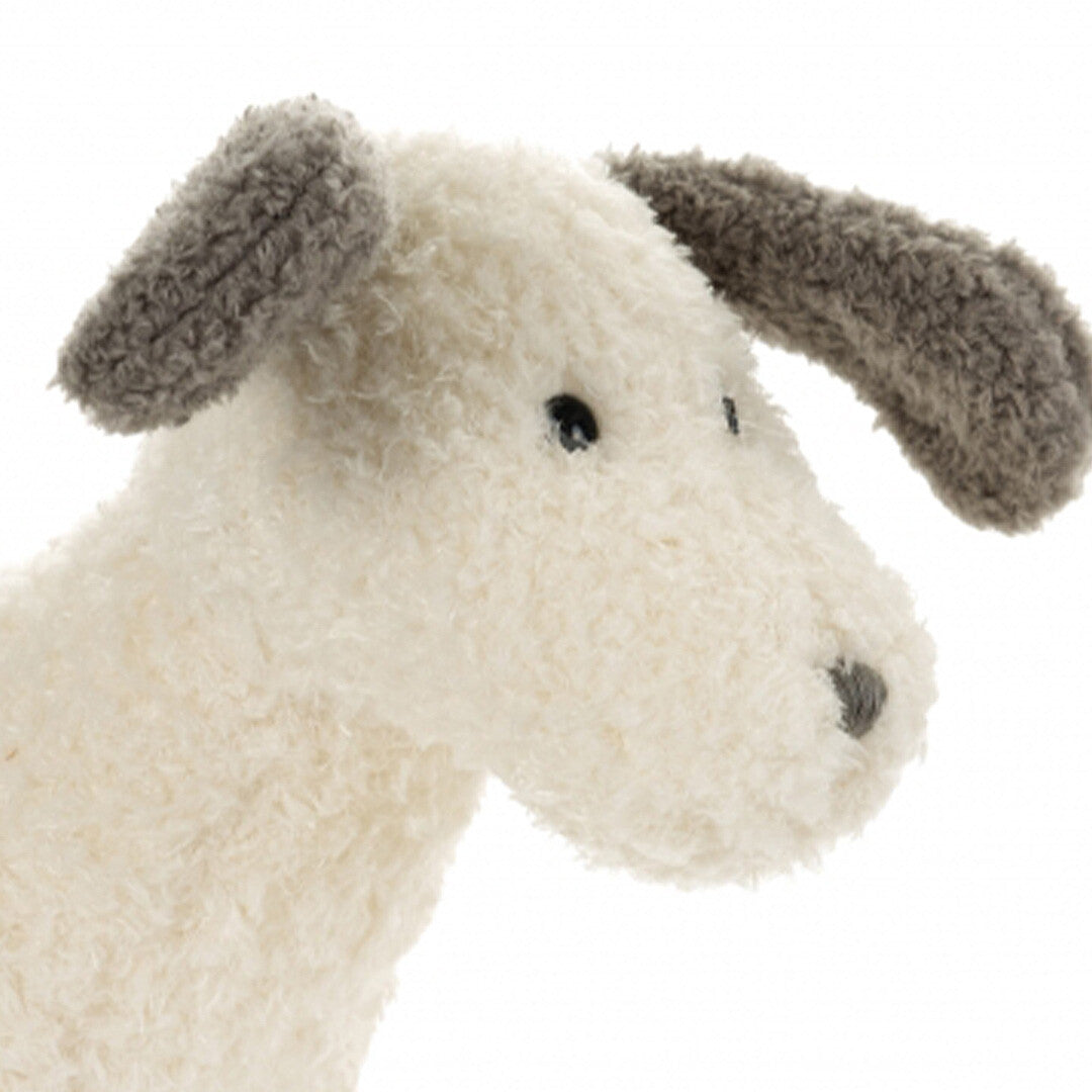 Detail van de kop van de witte pluchen knuffelhond Spotty met grijze oren en neus.