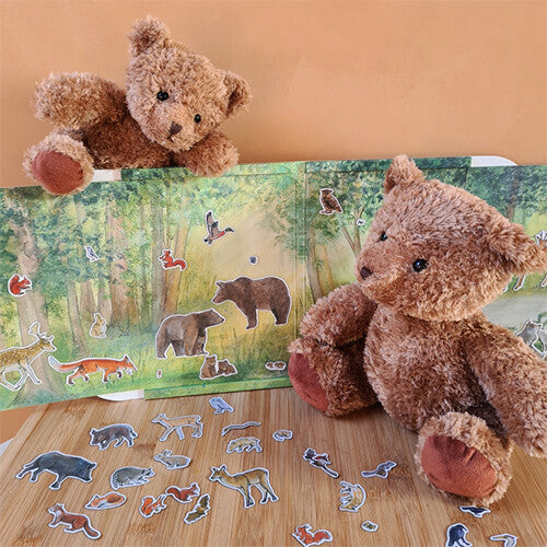 Twee teddyberen spelen met het Egmont Toys magneetboek bos en de losse magneetjes van bosdieren op een houten ondergrond.