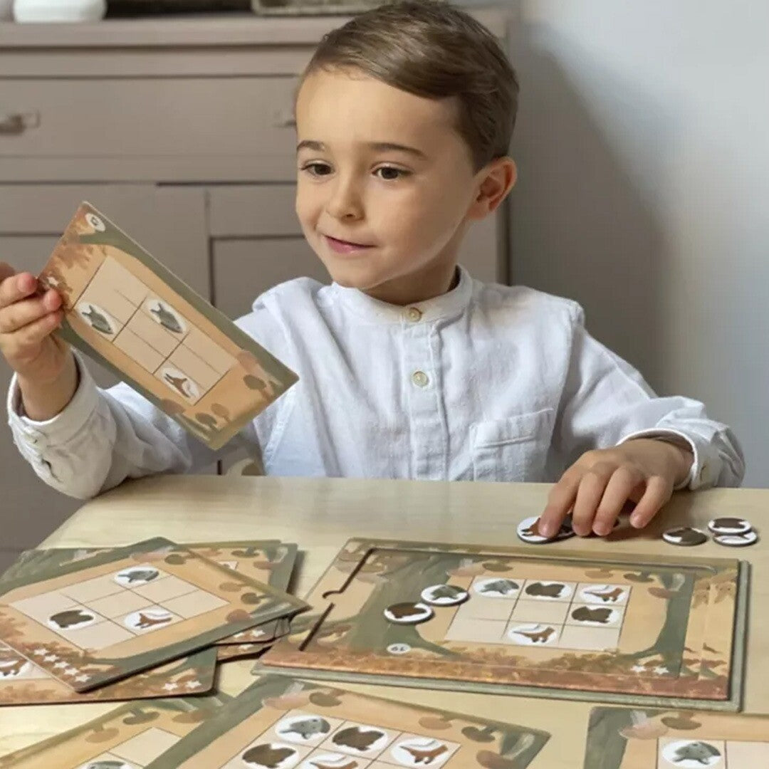 Een jongen speelt het Egmont Toys magnetische Sudoku Forest spel met dierenstukjes.