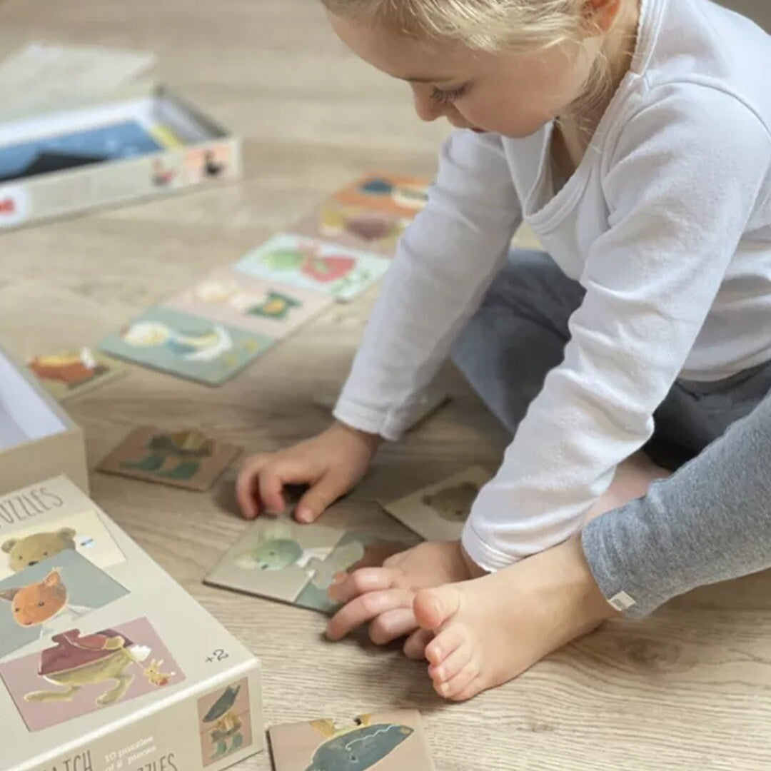 Een kind speelt op de grond met de Egmont Toys mix en match dierenpuzzelstukjes.