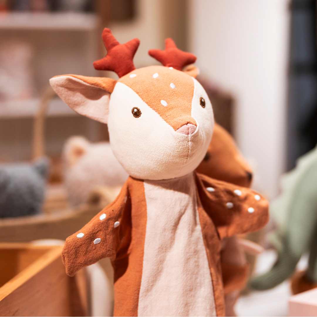 Egmont Toys handpop hertenkalf met rode geweitjes, schuin gefotografeerd in een winkelomgeving.