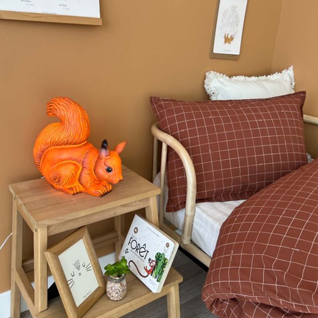 Egmont Toys eekhoorn nachtlamp op een nachtkastje naast een kinderbed.