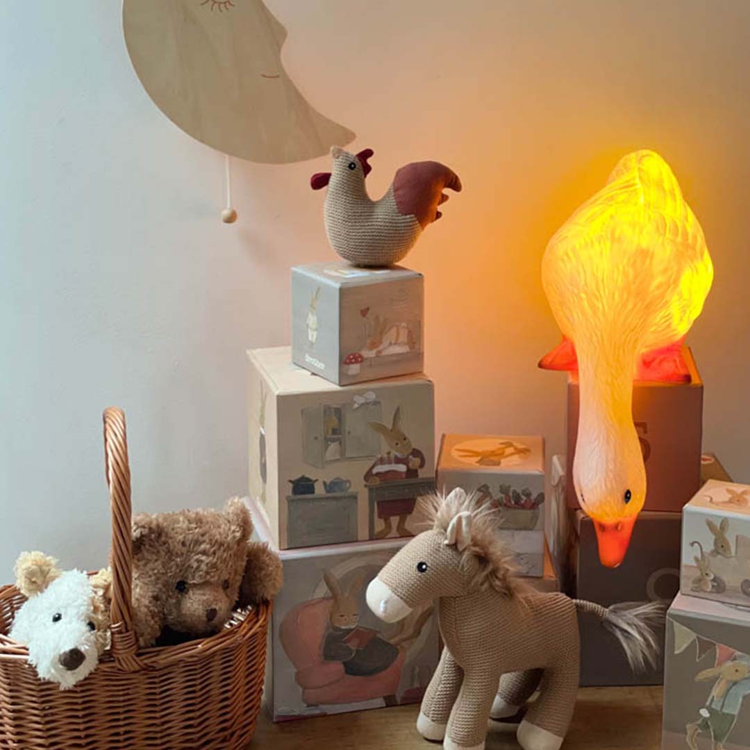 Egmont Toys Heico eendenlamp brandt geel in een kinderkamer tussen ander speelgoed.