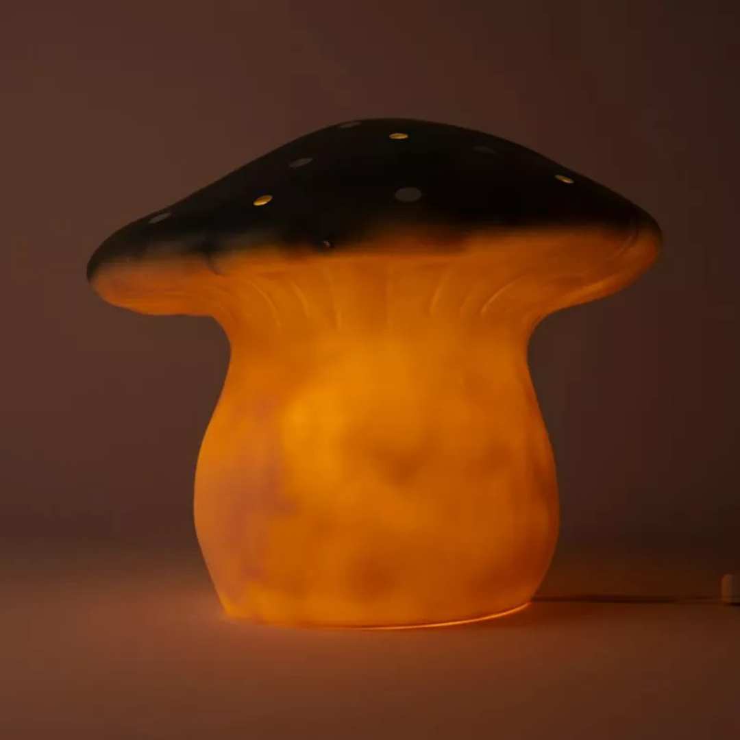 De Egmont Toys vliegenzwam nachtlamp gloeit warm oranje in het donker.