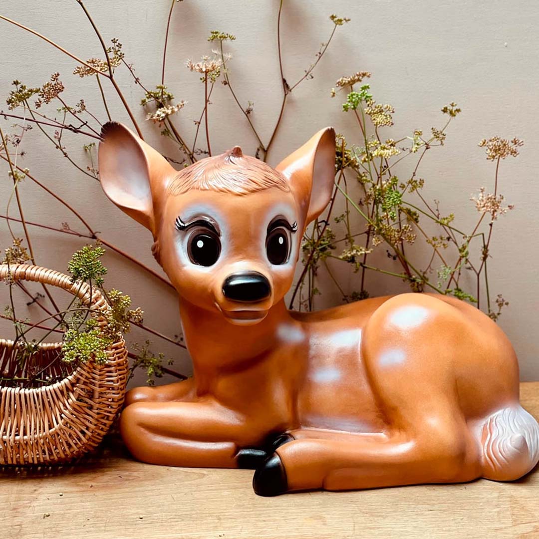 De Bambi hert lamp van Egmont Toys ligt naast een rieten mandje en gedroogde planten.