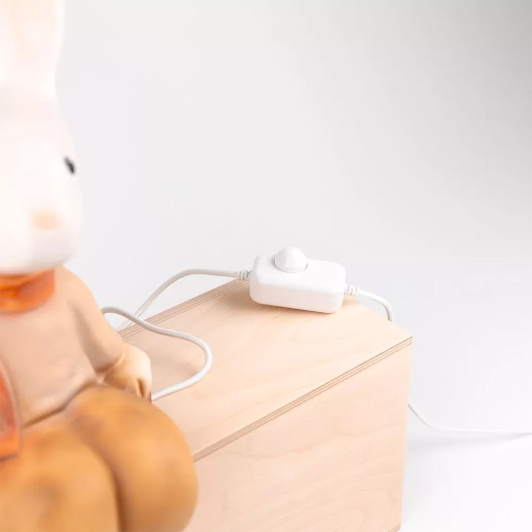 Detail van de dimmer schakelaar van de Egmont Toys Heico lamp konijn Lenny op een houten blok.