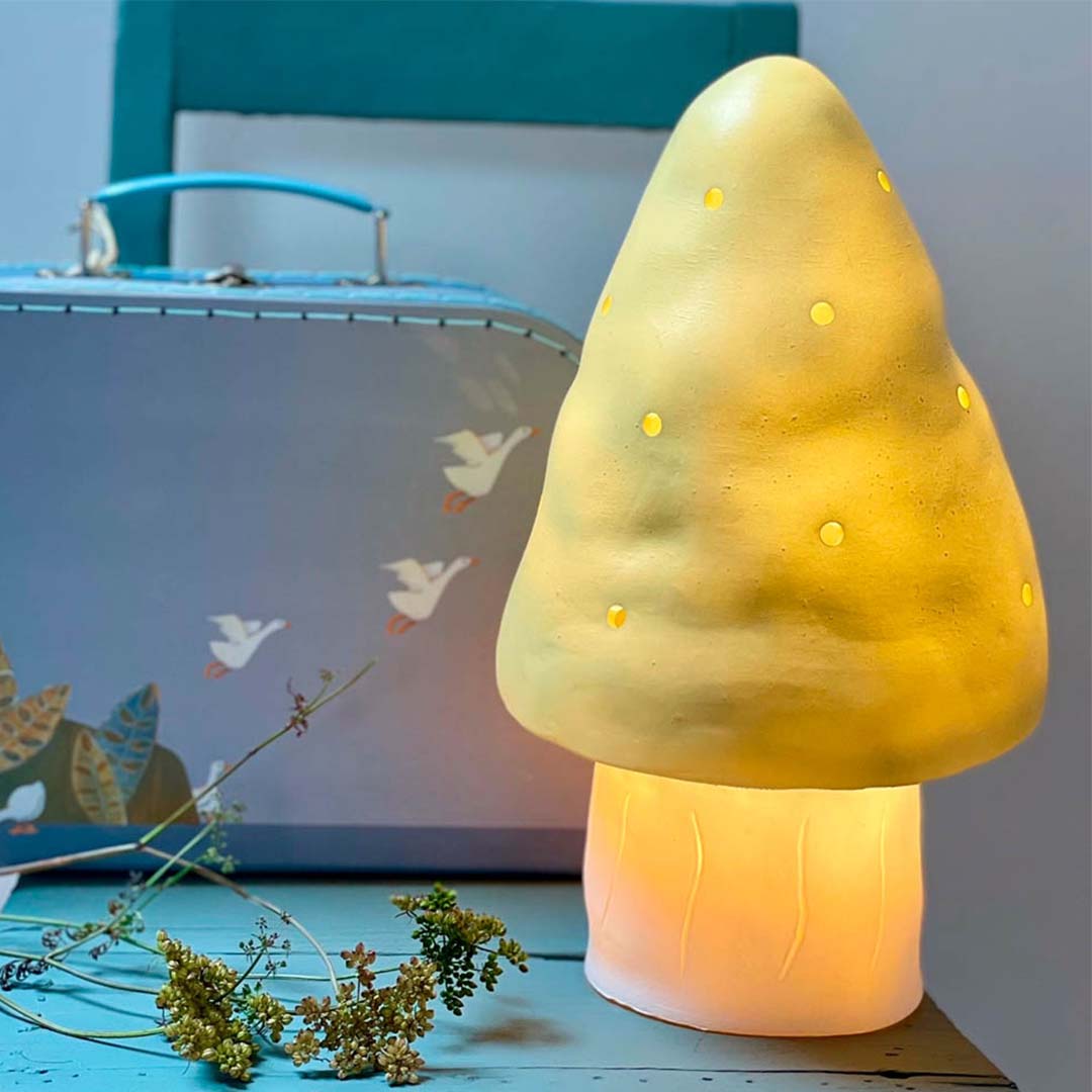 Egmont Toys paddenstoel nachtlamp verlicht op een blauwe ondergrond, naast een koffer met ganzen.
