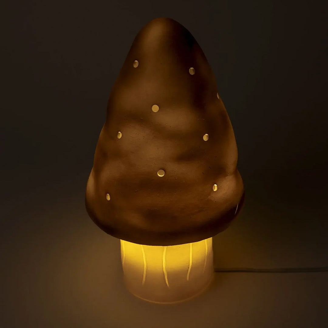 Verlichte paddenstoel nachtlamp met bronzen kap en lichtgevende steel in een donkere omgeving.