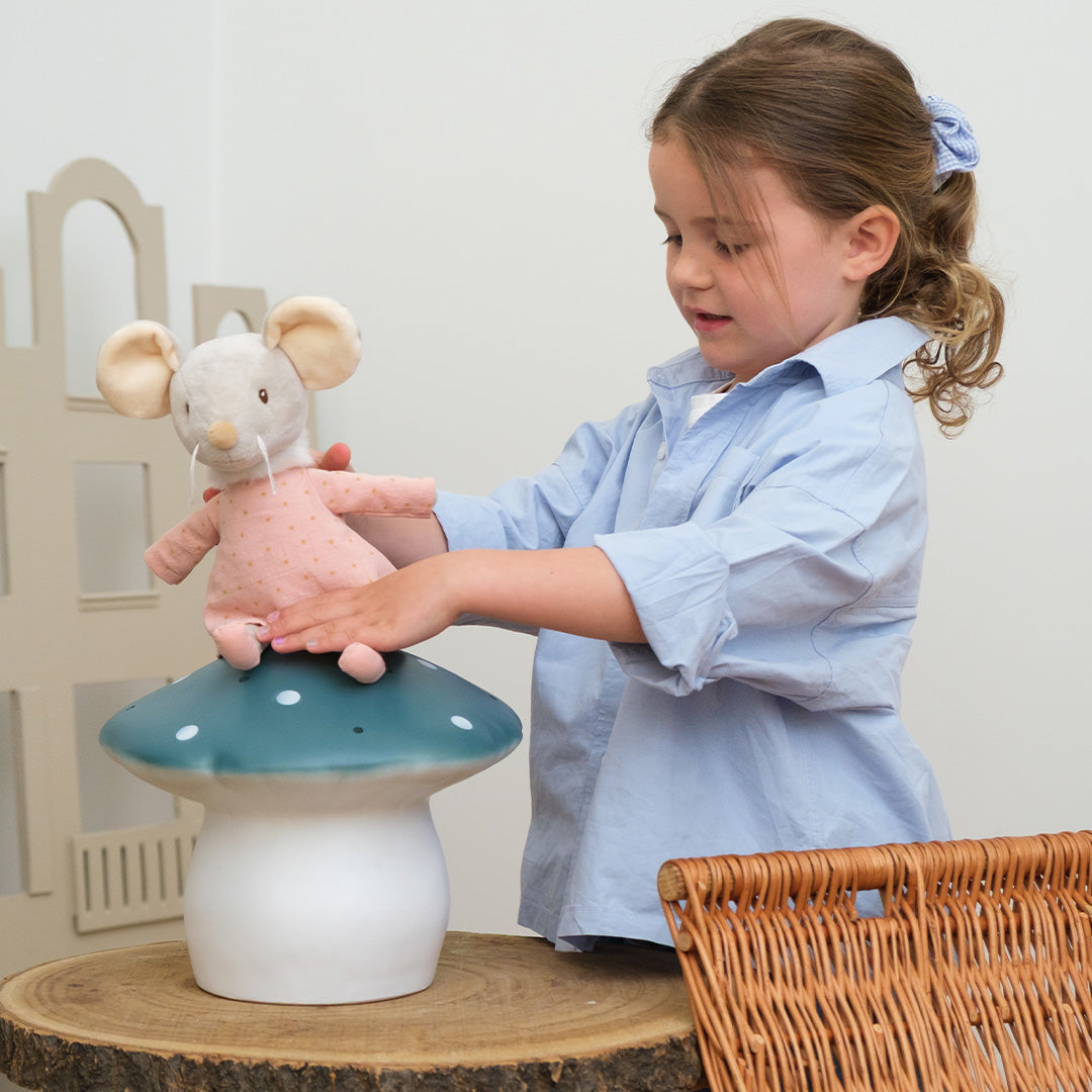 Meisje plaatst een knuffelmuis op de Egmont Toys Heico vliegenzwam lamp.