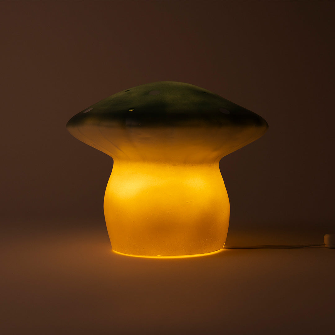 Brandende Egmont Toys Heico vliegenzwam lamp die warm geel licht uitstraalt.