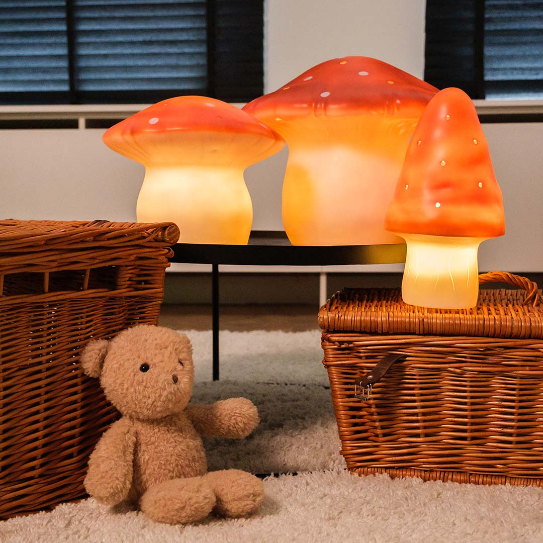 Drie verschillende Egmont Toys paddenstoel nachtlampen, verlicht, in een kinderkamer setting.