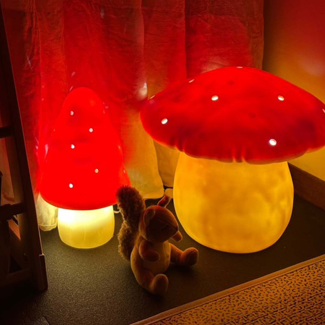 Twee verlichte paddenstoel nachtlampen en een knuffeleekhoorn in een schemerige kamer.