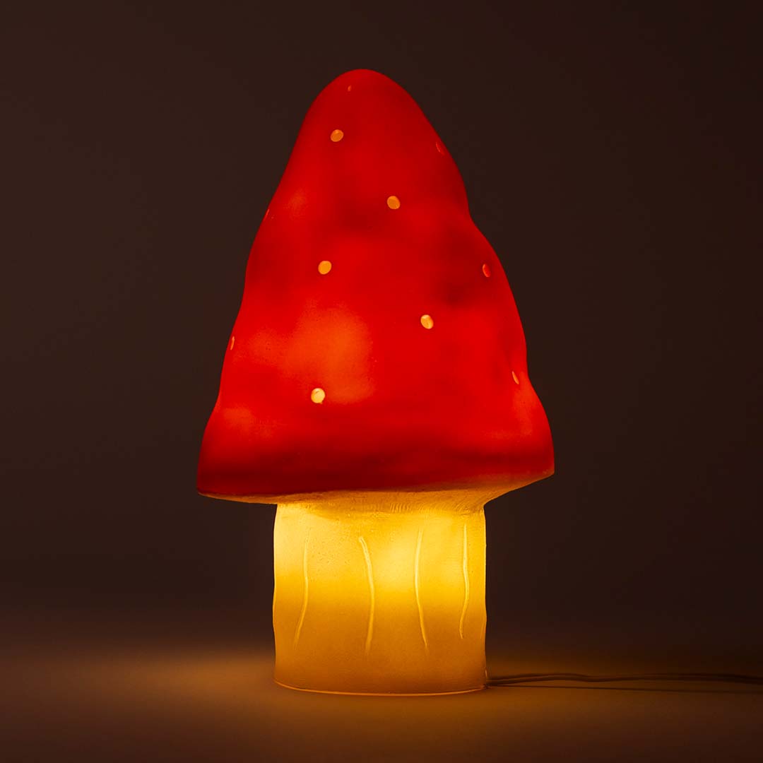 Egmont Toys rode paddenstoel nachtlamp verlicht met geelgloeiende steel op een donkere achtergrond.