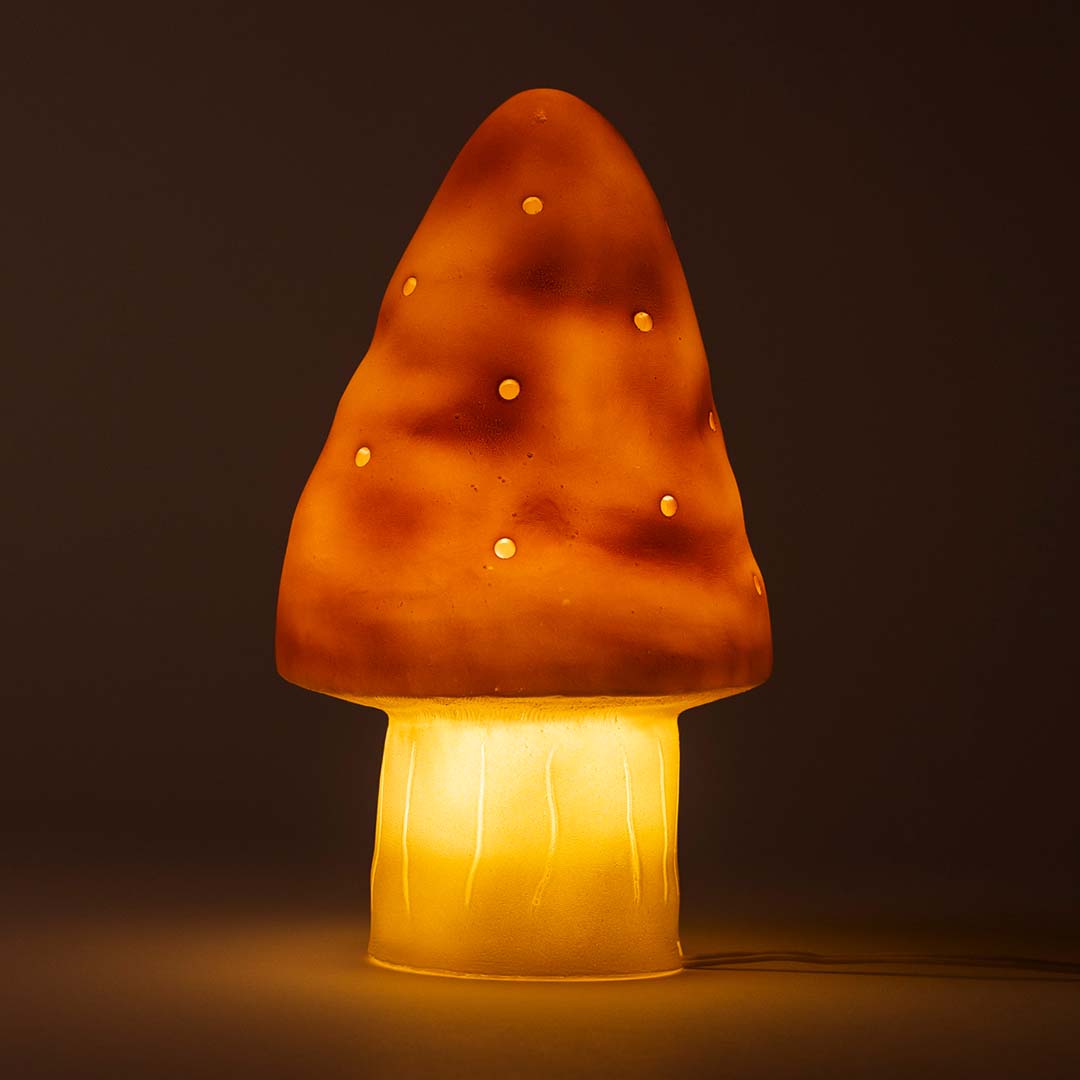 Egmont Toys paddenstoel nachtlamp met oranje kap en witte steel, ingeschakeld en warm licht gevend.