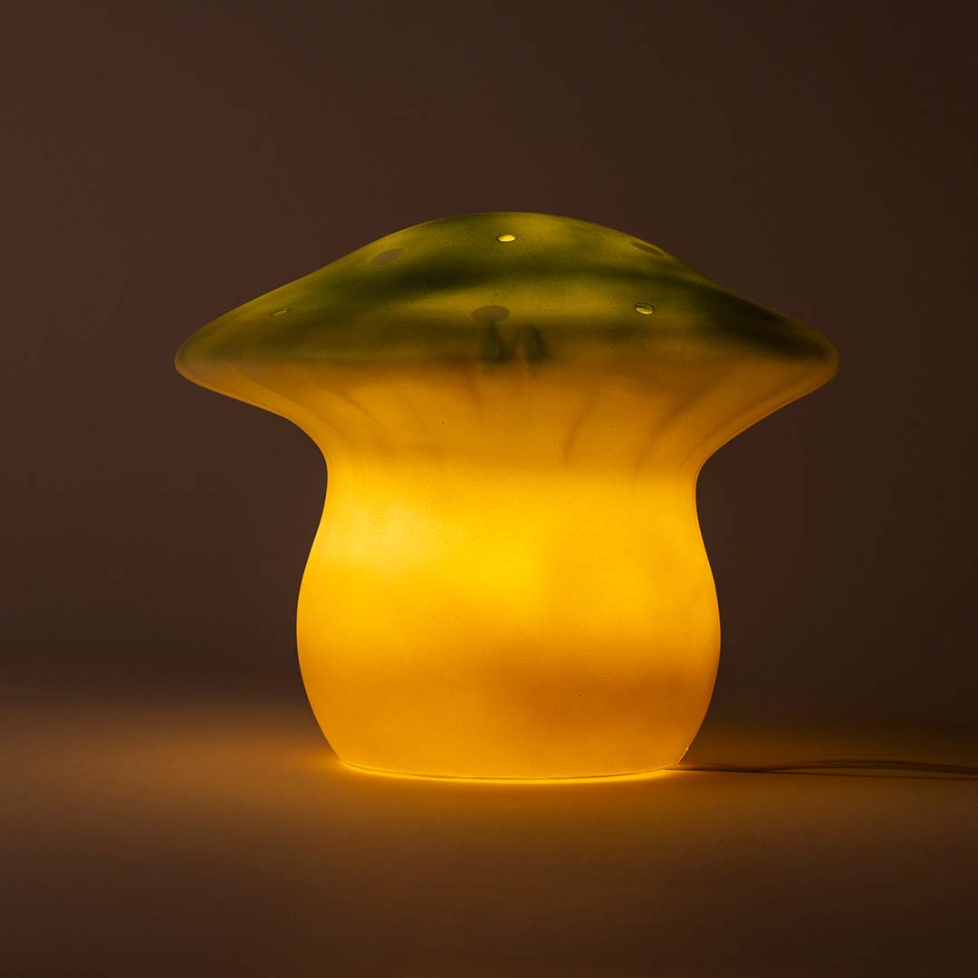 De paddenstoel nachtlamp brandt en geeft warm geel licht.