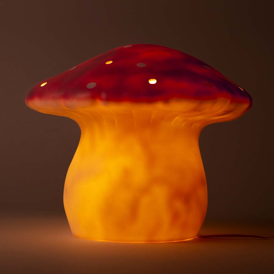 Een brandende vliegenzwam bedlamp met een warme oranje gloed.