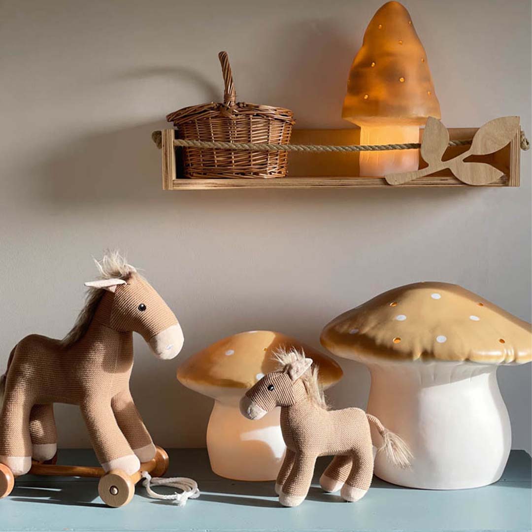 Drie Egmont Toys vliegenzwam nachtlampen in verschillende maten staan samen met twee paardenspeeltjes.