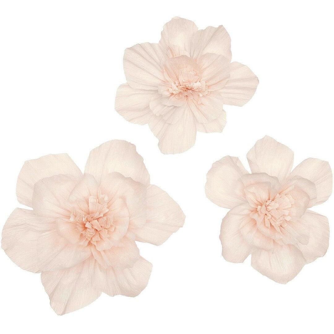 Drie roze crêpepapier bloemen los op een witte achtergrond.