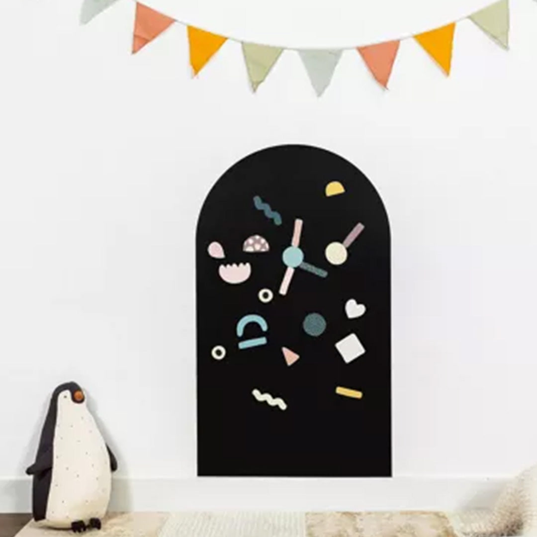 Ferflex zwart magneetbord in boogvorm met kleurrijke abstracte magneten in een kinderkamer.