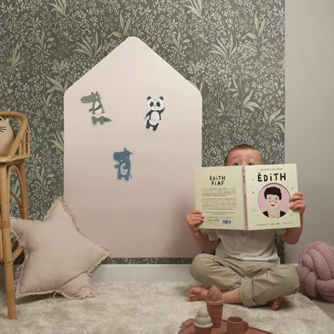Kind zit voor het Ferflex huisvormige magneetbord met dierenmagneten en een boek.