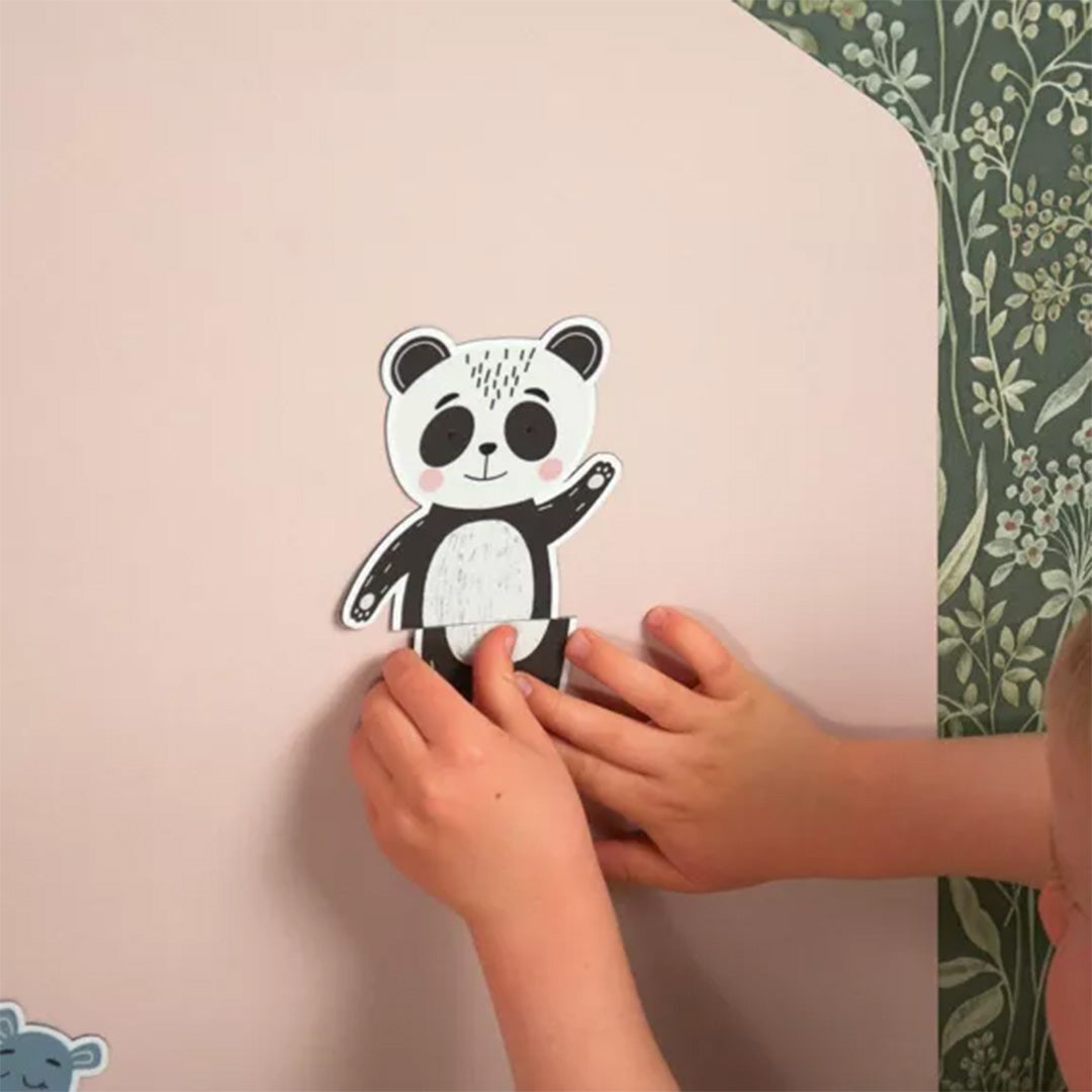 Kinderhanden plaatsen een panda magneet op het Ferflex huisvormige magneetbord.