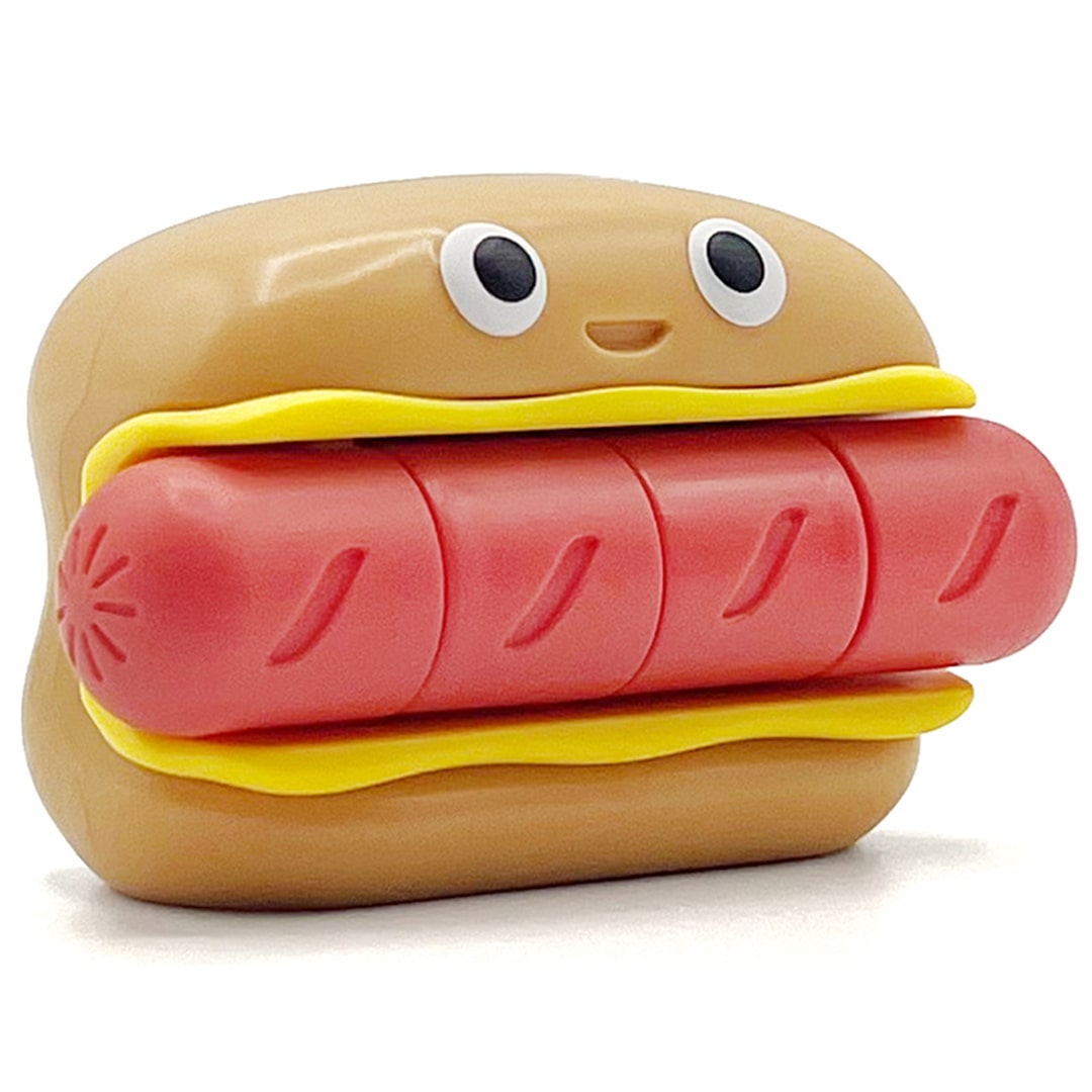Fidget go friemelspeelgoed in de vorm van een hotdog met een vrolijk gezichtje, schuin van voren gefotografeerd.