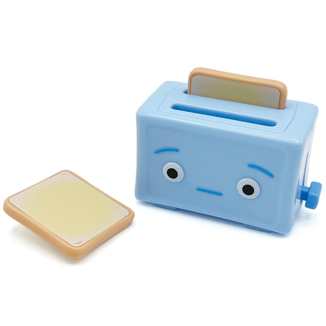 Fidget go friemelspeelgoed blauwe broodrooster met een verdrietig gezicht en twee stukjes toast, waarvan één ernaast ligt.