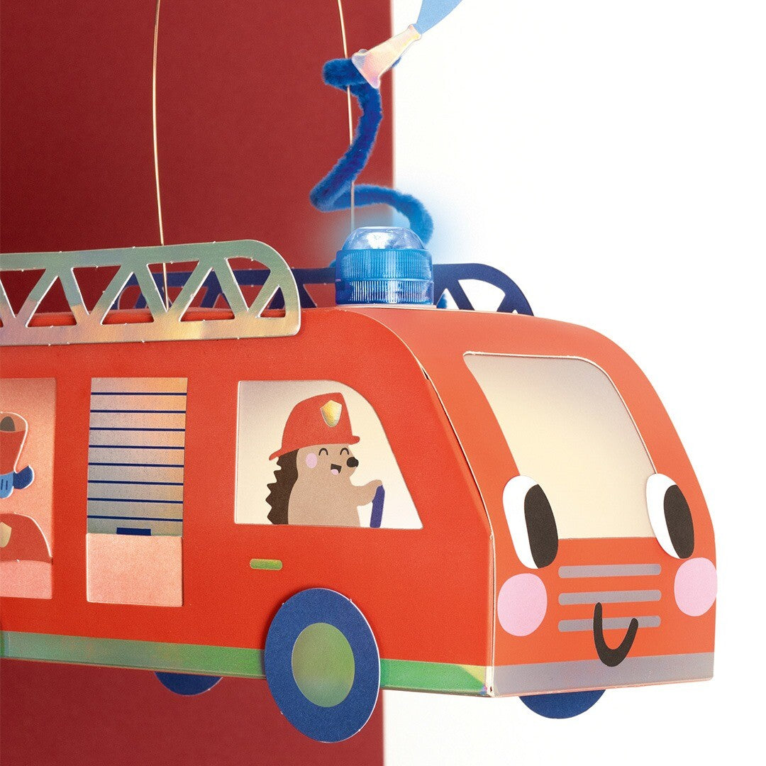 Detail van een brandweerwagen lantaarn met een blauw zwaailicht en een egel als bestuurder.
