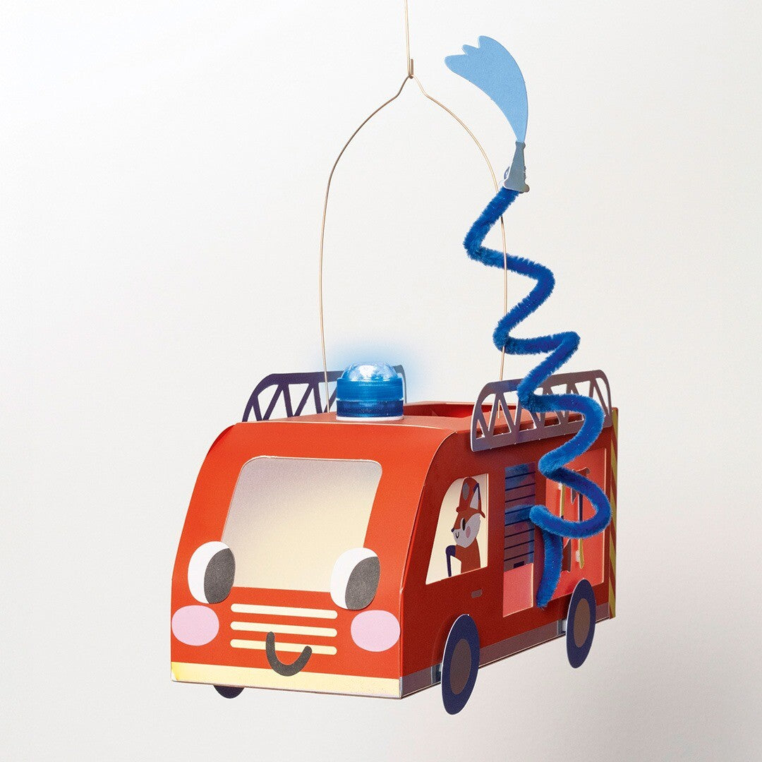 Een hangende brandweerwagen lantaarn met een blauw knipperlicht en een waterslang van chenilledraad.