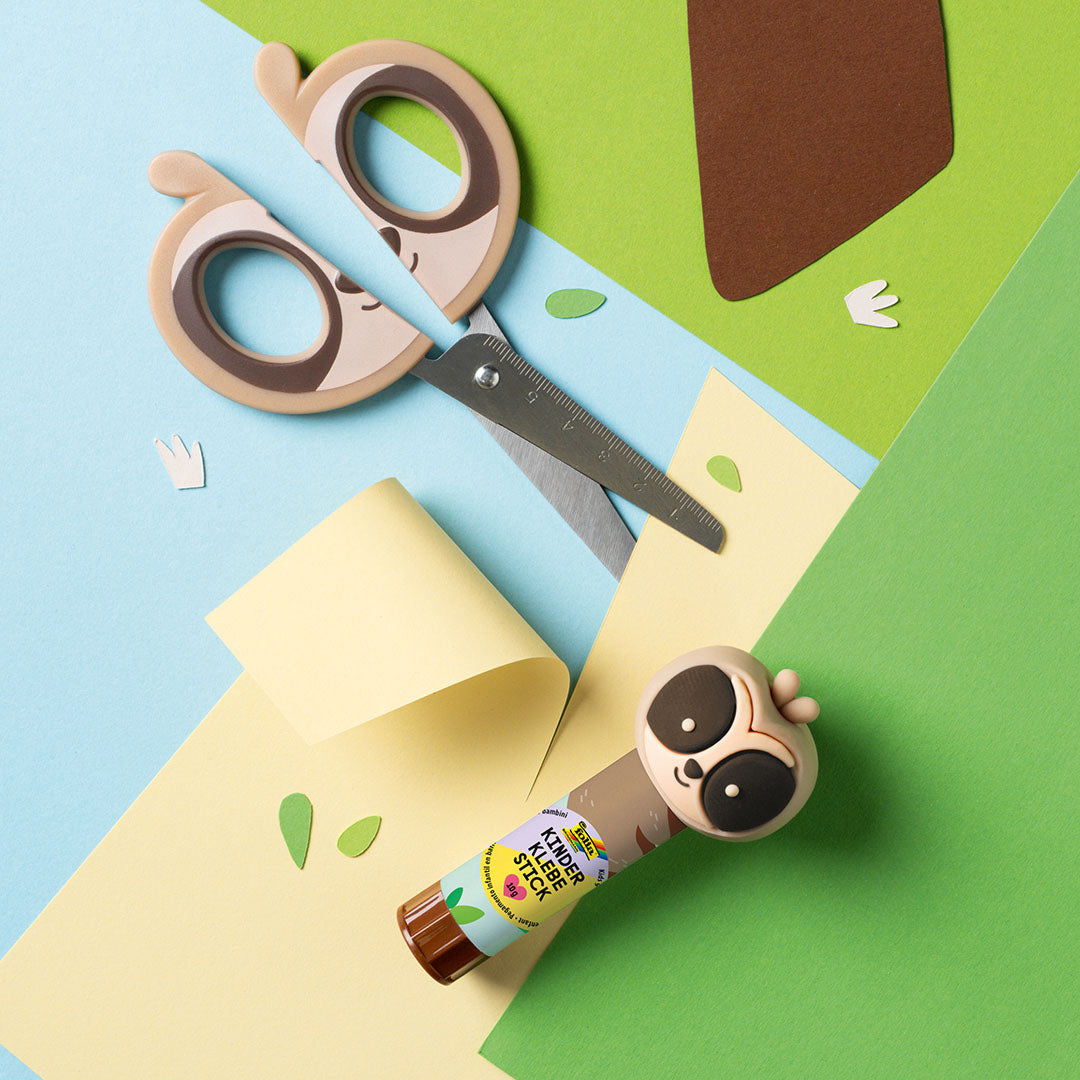 Folia kinderschaar met luiaardthema en een lijmstift op een knutselachtergrond.