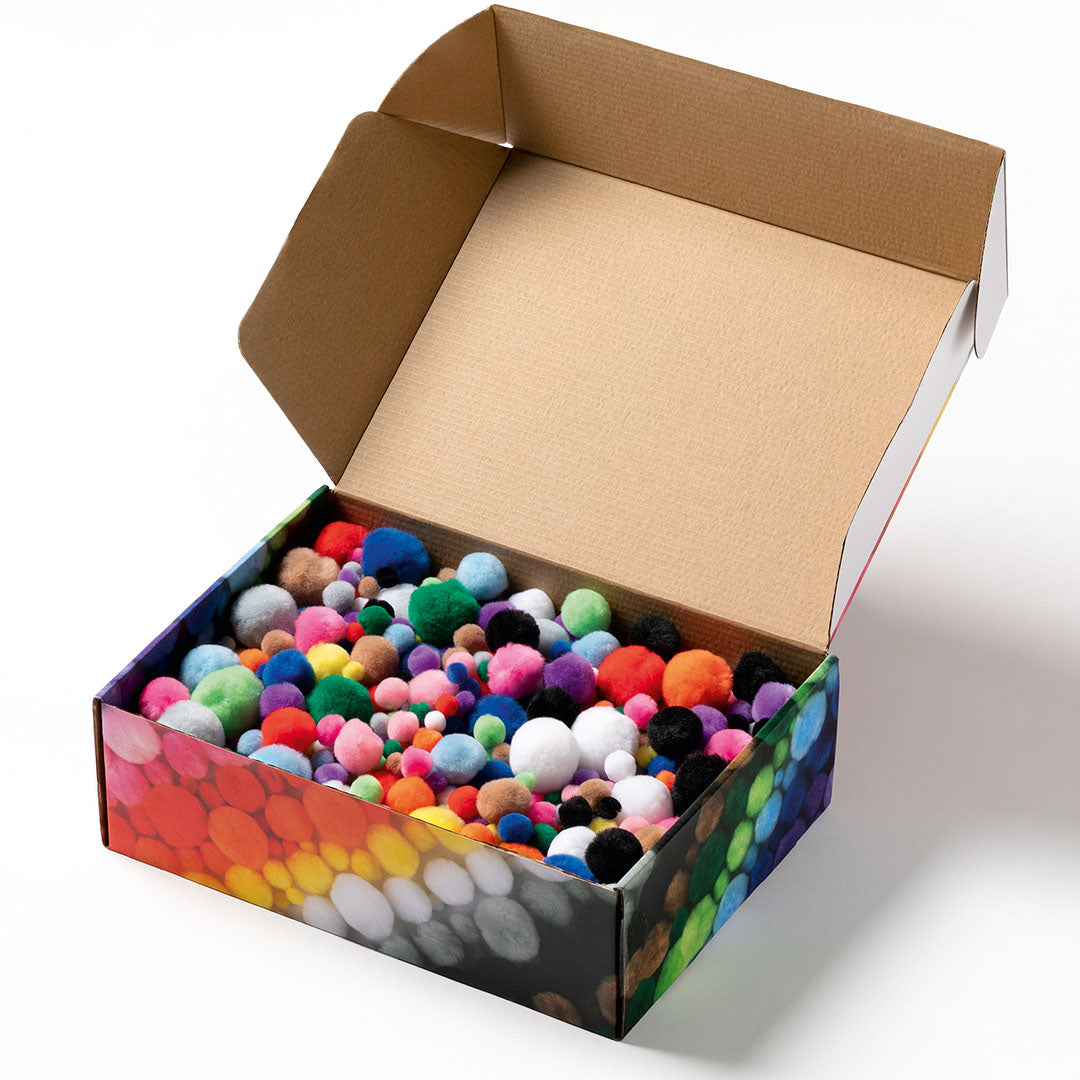 Open doos met een grote hoeveelheid kleurrijke pluche pompoms in verschillende maten.