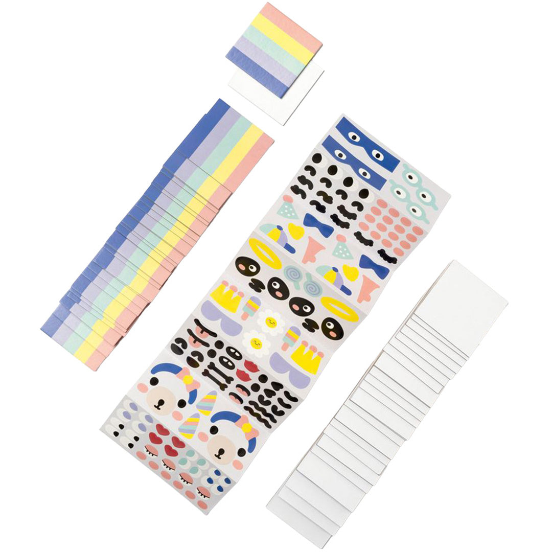 Diverse materialen van de folia DIY legekaarten hobbyset, waaronder regenboogstroken, een stickervel met gezichtjes en blanco kaarten.