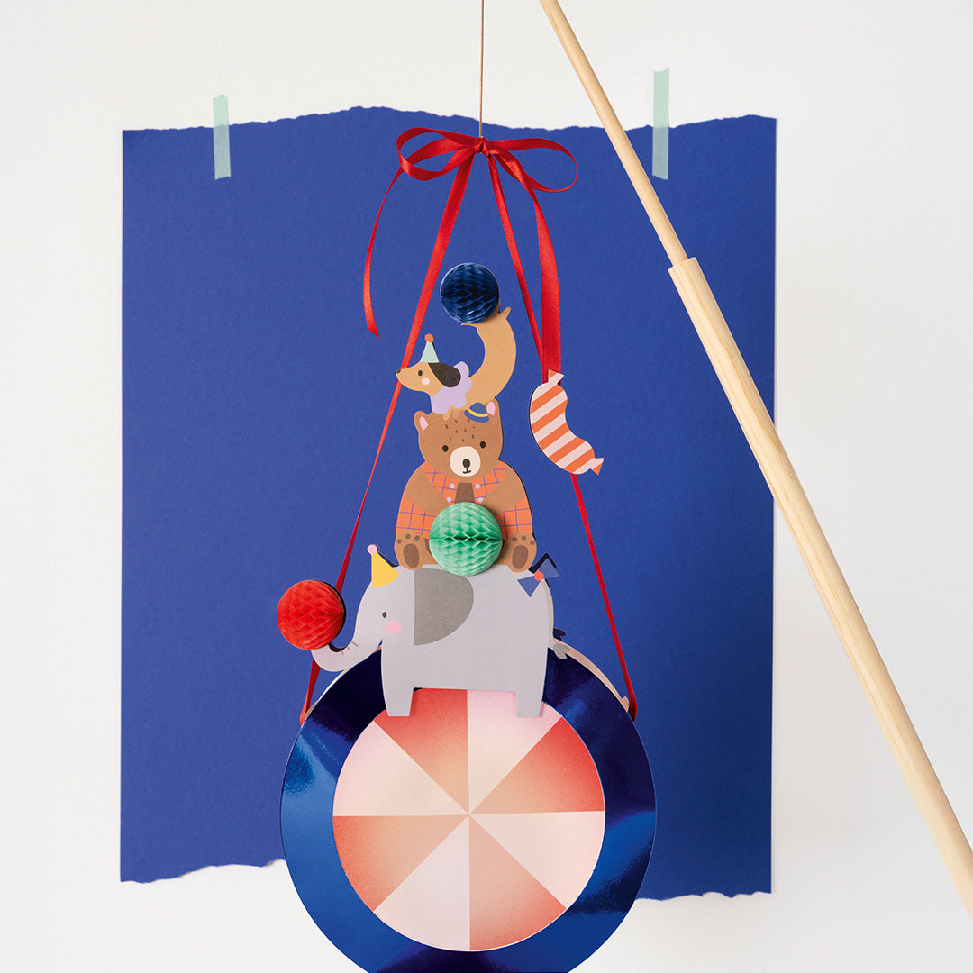 De folia circus lantaarn met gestapelde dieren, hangend aan een houten stok.